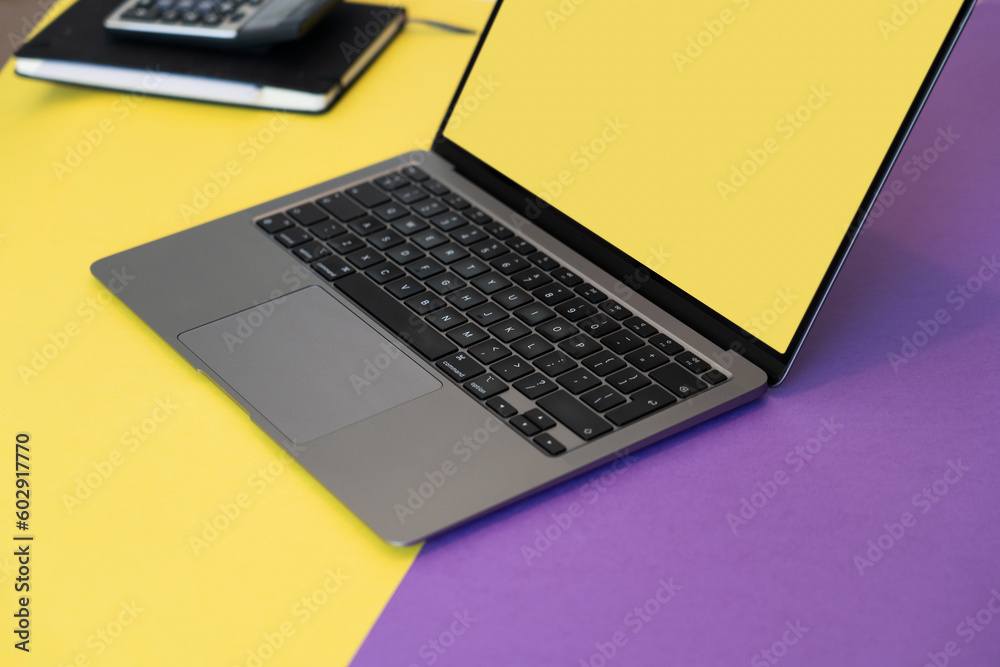 Open laptop with blank screen. Screen mockup. Yellow and purple blank background. Open laptop with blank screen. Screen mockup. Yellow and purple blank background.
