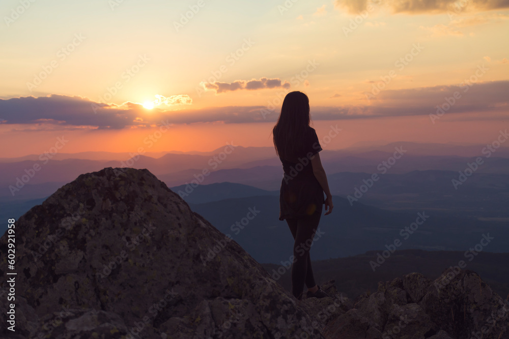 Woman Silhouette in the Mountain on Orange Sunset Cloudy Sky Background .Orange Sunset in Vitosha Mountain ,Bulgaria 