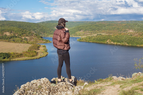 Traveler woman walking above a blue lake with stunning panoramic view .Traveling in the nature in Bulgaria . Pchelina Lake photo