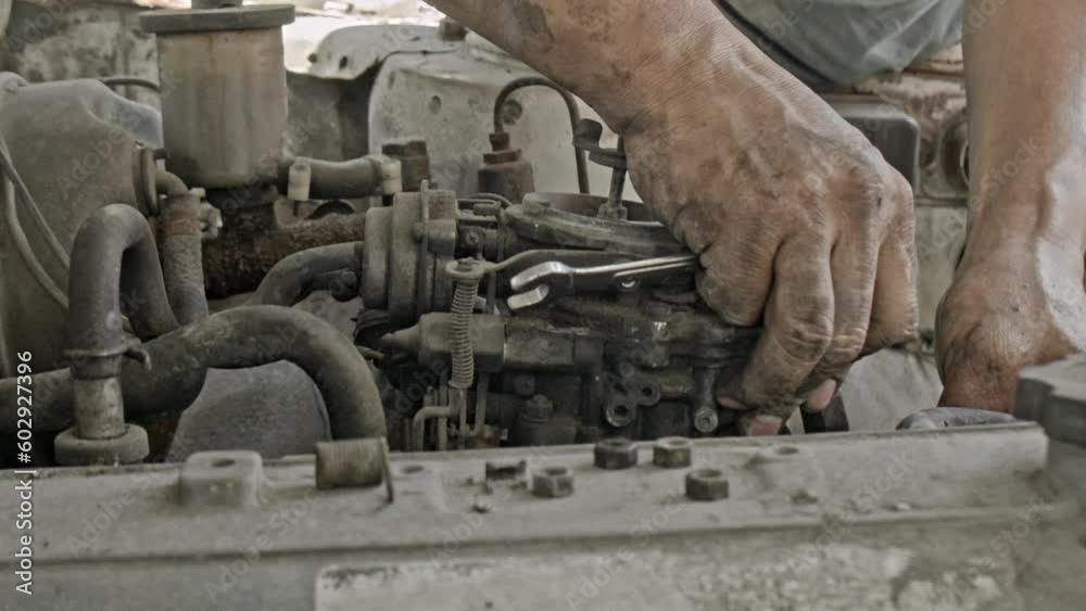 Carburetor being removed by greasy mechanic's hands Carburetor being removed by greasy mechanic's hands