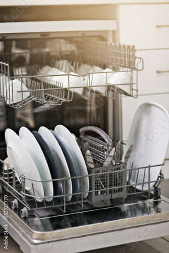 Backgrounds, dishwasher and machine for cleaning dishes, washing, dirty kitchenware and easy housekeeping process. Closeup of electrical appliance with plates, cups and crockery for hygiene at home