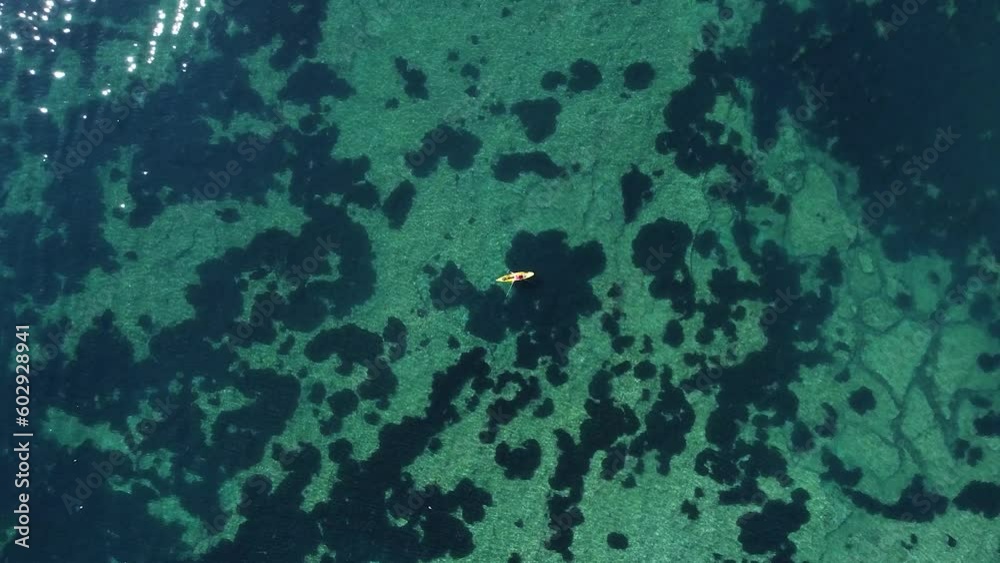 Kayak at the beach drone view. Kayaker trolling fishing from aerial point of view at Mediterranean sea Kayak at the beach drone view. Kayaker trolling fishing from aerial point of view at Mediterranean sea