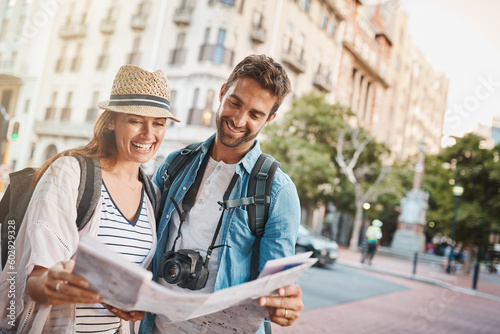 Tourist, couple and a map in a city for travel and search for street, location or direction. Man and a woman reading a paper for navigation outdoor on urban road for adventure, journey or vacation