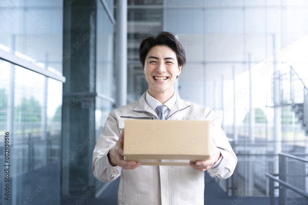 Logistics and transportation image Fresh Asian worker delivering packages at a factory, warehouse or distribution center Close-up looking at camera Logistics and transportation image Fresh Asian worker delivering packages at a factory, warehouse or distribution center Close-up looking at camera