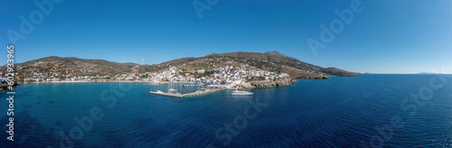 Andros island  panorama of Batsi village  Cyclades Greece. View from ship of port  sea  sky. Banner