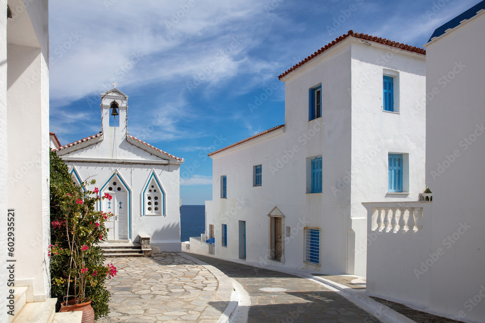 Andros island, Chora town, Cyclades Greece. Agia Varvara white orthodox church, sea sky sunny day.
