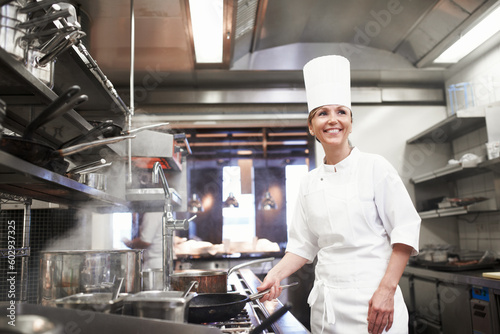Chef, woman and smile with frying pan in kitchen, catering service and prepare food for fine dining in restaurant. Professional, cooking and female person saute, cook and thinking about hospitality.