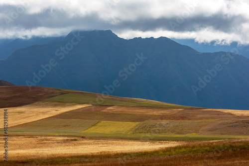 A view of the Andes Mountain range as seen from a patchwork farming land near Maras in Peru. Maras is a town in the Sacred Valley of the Incas, 40 kilometers north of Cusco in the Urubamba Province. photo