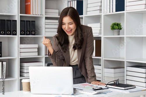 Overjoyed young businesswoman with laptop expressing excitement rejoicing in office, Excited business woman feel euphoric reading good news online