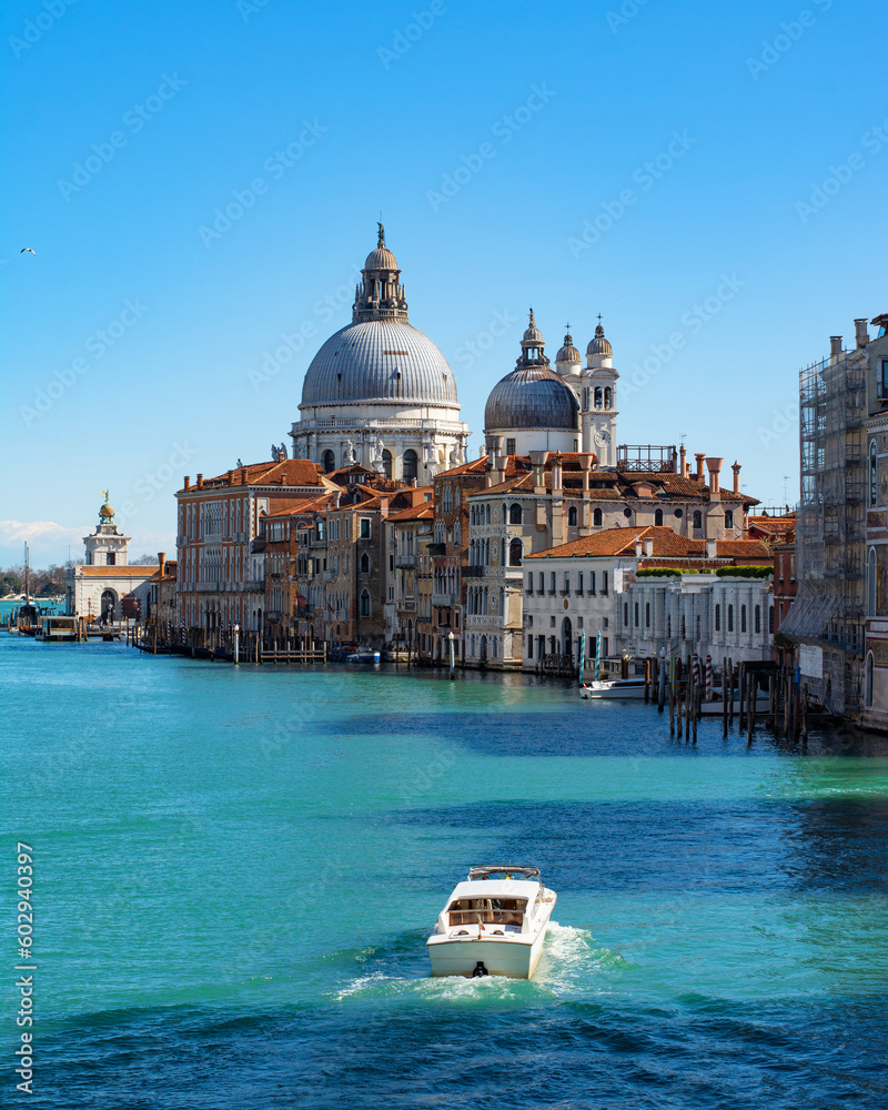 Stunning view of the Venice skyline with the Grand Canal and Basilica Santa Maria Della Salute in the distance from Ponte Dell’ Accademia in a sunny weather with clear sky. Veneto, Italy