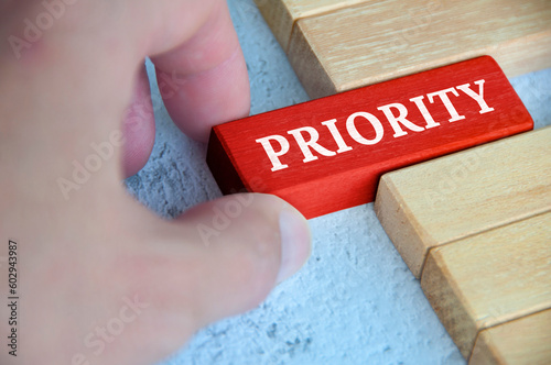 Картината върху платно Hand placing red wooden blocks with text - Priority