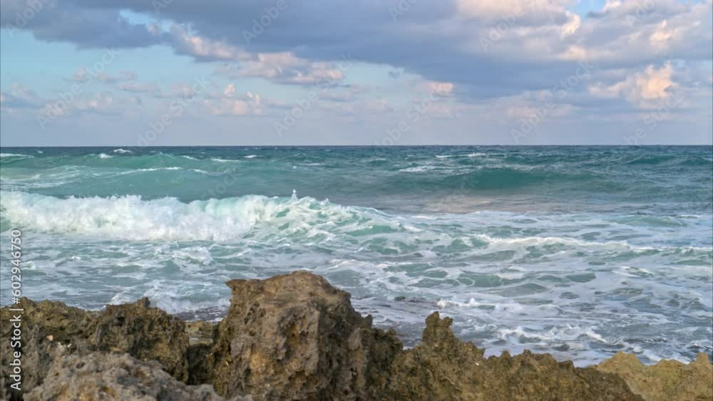 Panning in slow motion of the caribbean sea and some waves braking near a rocky beach in Mexico Panning in slow motion of the caribbean sea and some waves braking near a rocky beach in Mexico
