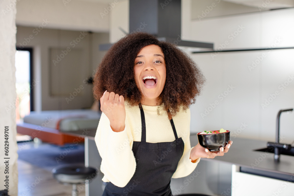 pretty afro black woman feeling shocked,laughing and celebrating success. japanese noodles ramen concept pretty afro black woman feeling shocked,laughing and celebrating success. japanese noodles ramen concept