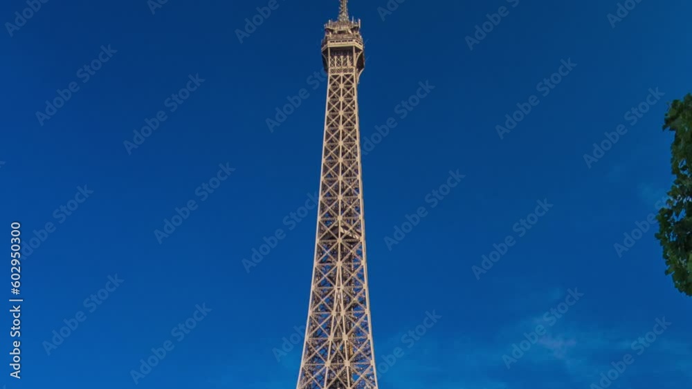 Eiffel Tower with bridge over Siene river in Paris timelapse hyperlapse, France. Blue cloudy sky at summer day with green trees and people walking over bridge Eiffel Tower with bridge over Siene river in Paris timelapse hyperlapse, France. Blue cloudy sky at summer day with green trees and people walking over bridge