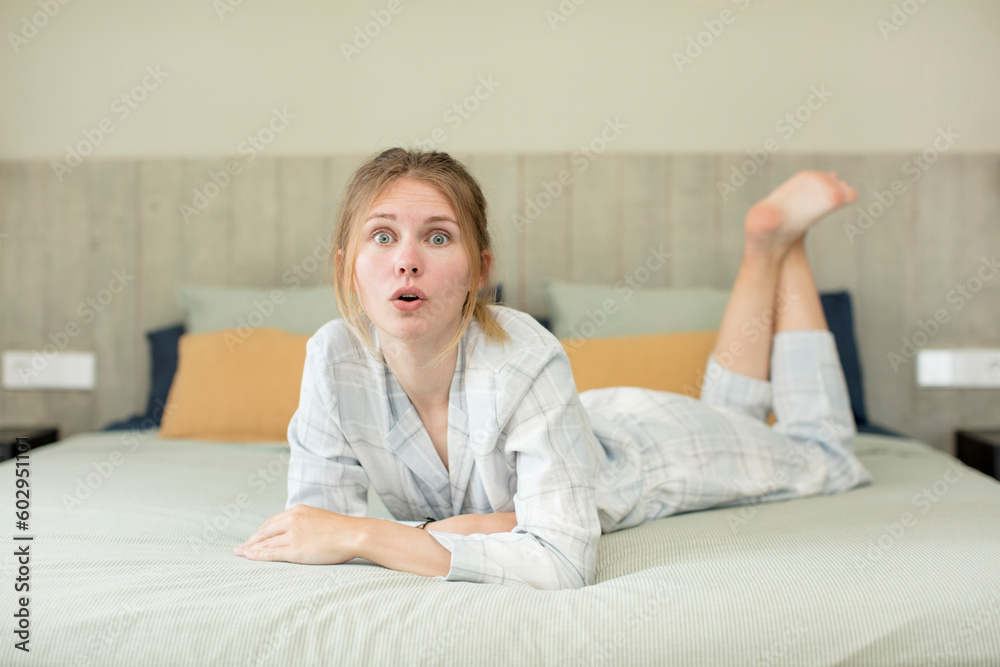 young pretty woman feeling extremely shocked and surprised. nightwear concept young pretty woman feeling extremely shocked and surprised. nightwear concept