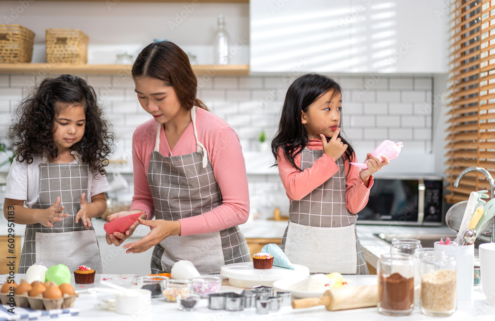 Portrait of enjoy happy love asian family mother and little toddler asian girl daughter child having fun cooking together with dough for homemade bake cookie and cake ingredient on table in kitchen Portrait of enjoy happy love asian family mother and little toddler asian girl daughter child having fun cooking together with dough for homemade bake cookie and cake ingredient on table in kitchen