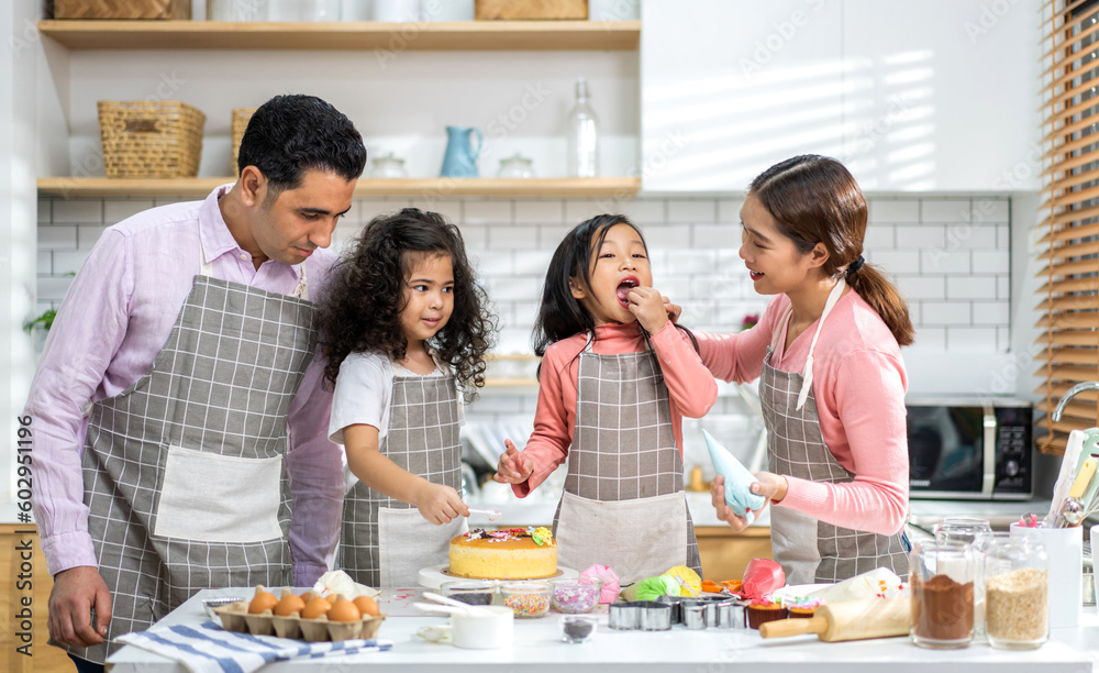 Portrait of enjoy happy love asian family father and mother with little asian girl daughter child play and having fun cooking food together with baking cookie and cake ingredient in kitchen