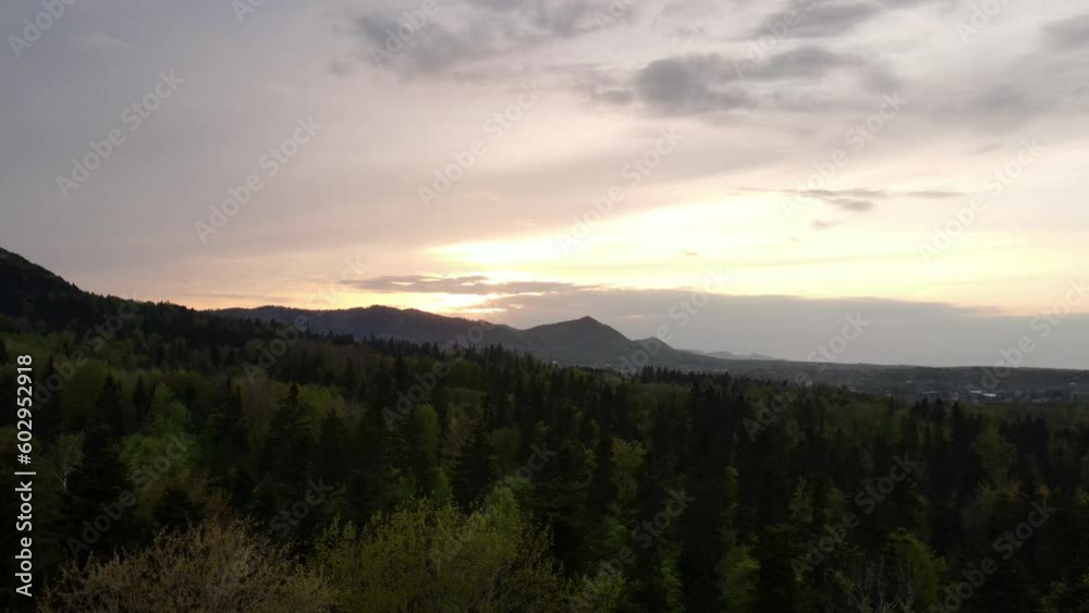 Aerial drone shot of dramatic orange sunset or sunrise evening over beautiful calm mountains in countryside at springtime. Cloudy colors of sky. Silhouette various forest. Nature and landscape concept Aerial drone shot of dramatic orange sunset or sunrise evening over beautiful calm mountains in countryside at springtime. Cloudy colors of sky. Silhouette various forest. Nature and landscape concept
