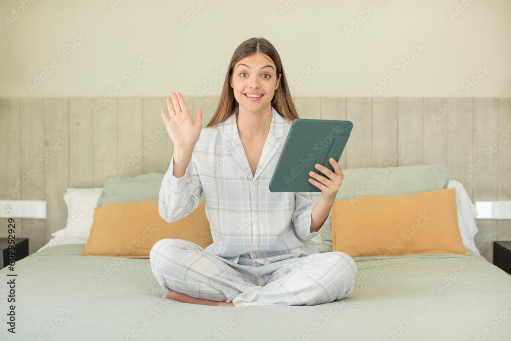 young pretty woman feeling happy and astonished at something unbelievable. touchscreen pad concept