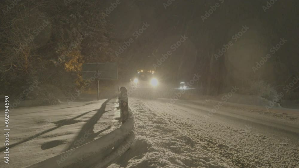 Snow plow clearing a road at nigh, Winterberg, Germany