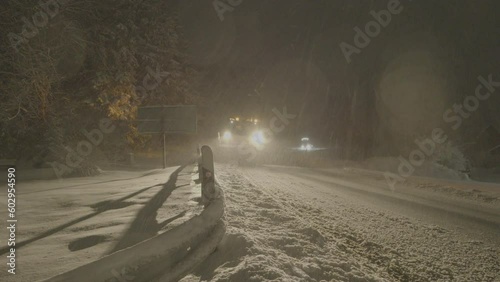Snow plow clearing a road at nigh, Winterberg, Germany