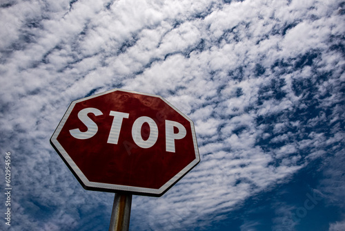 cartel de stop con cielo lleno de nubes