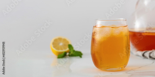 A glass with a summer cooling drink. Iced tea with lemon and mint. Copy space