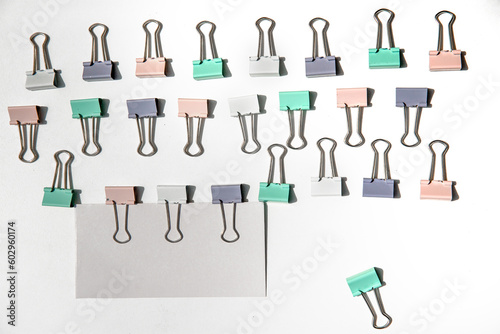 white note hold by metal paper clips isolated over white background, business concept, memory reminder paper, work or educational tools