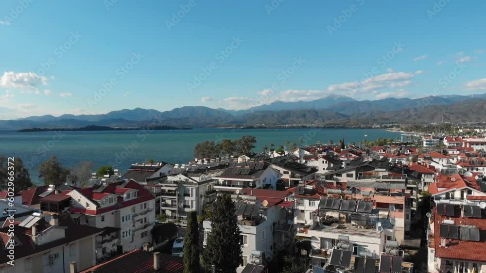 Drone flying forward over the old town off the coast with mountains in the background. Beautiful scenery of fethiye town in turkey. High quality 4k footage Drone flying forward over the old town off the coast with mountains in the background. Beautiful scenery of fethiye town in turkey. High quality 4k footage