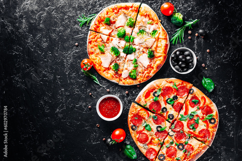 Pepperoni Pizza with Mozzarella cheese, salami, Tomatoes, olive, pepper, Spices and Fresh Basil and Pizza with cheese, salmon fish, broccoli, tomato sauce. two Italian pizza on dark background
