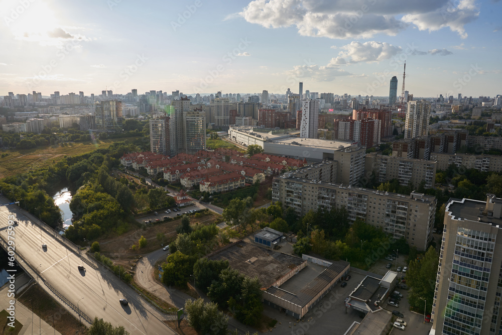The dense construction of the city is visible from above. Small two-storey houses stand in a row. Against the background of a blue sky with clouds, a bird's-eye view of the millionaire city.