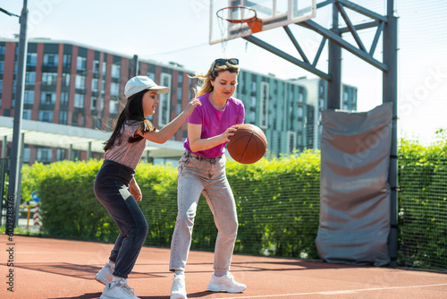 Mother and daughter playing basketball © Angelov