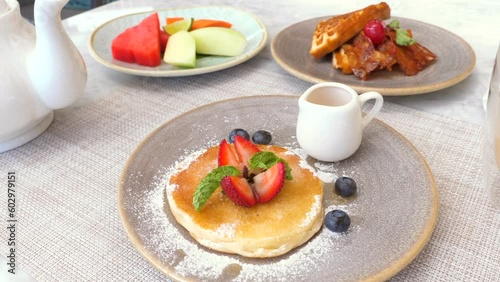 Delicious sweet food. Fresh pancake with berries, waffles and fruits on the table in cafe. Sugar, non health food concept. photo