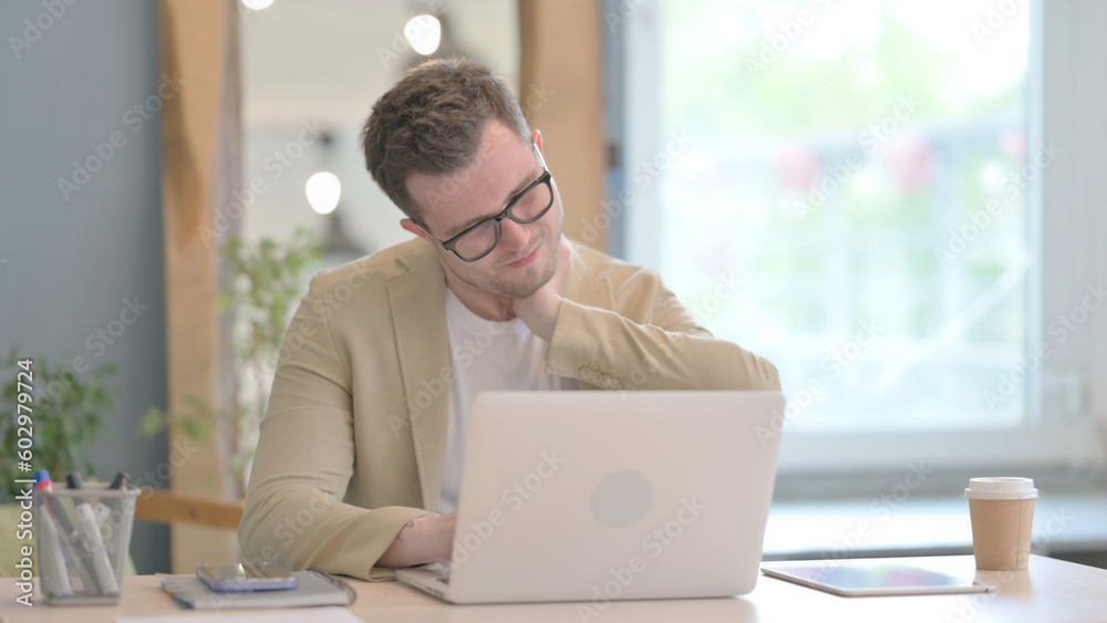 Young Businessman with Neck Pain Working on Laptop