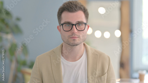 Portrait of Serious Young Businessman Looking at Camera