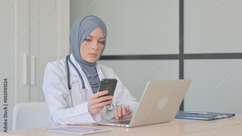 Muslim Female Doctor Using Smartphone in Clinic Muslim Female Doctor Using Smartphone in Clinic