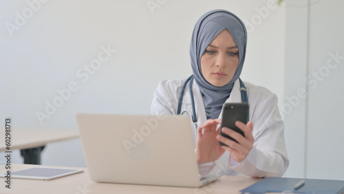 Muslim Female Doctor Using Smartphone in Clinic