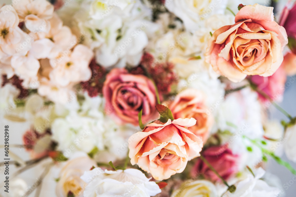 Background of white, cream, pink roses and other flowers as part of a festive decoration, selective soft focus. Background of white, cream, pink roses and other flowers as part of a festive decoration, selective soft focus.