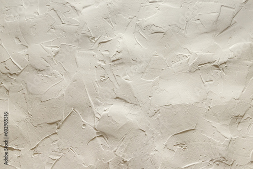 The uneven surface of a beige clay wall. High quality photo