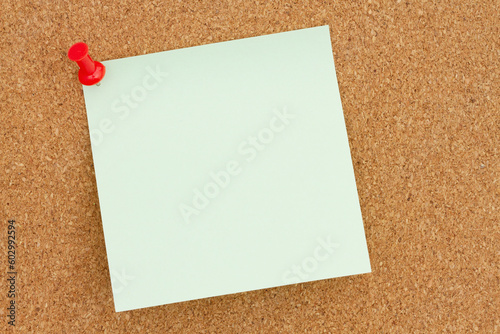 Blank green sticky note on bulletin board