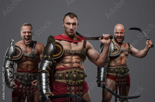 Shot of roman gladiators dressed in light armour screaming to camera.