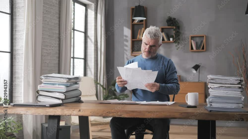 financial issue concerned man looks at tax bills gets upset,bank loan,frustrated person at the desk looking at the account statement expenses gets angry financial issue concerned man looks at tax bills gets upset,bank loan,frustrated person at the desk looking at the account statement expenses gets angry