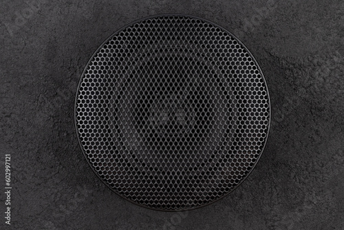 фотографія Stylish car audio acoustic round speaker with waffle grill protector cover on dark black background closeup