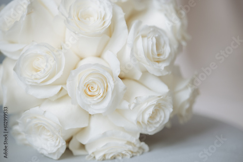 Wedding bouquet of white roses on a white background with soft focus and copy space.