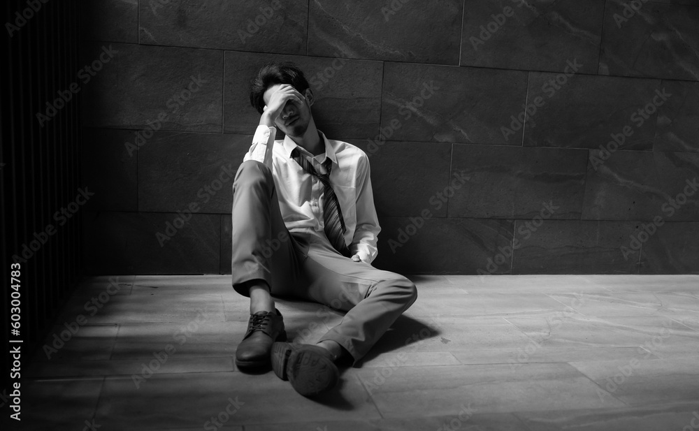 Portrait man stressed sad and tired from over working. Overworked and worried. male business man worker sitting on the floor and dark background Portrait man stressed sad and tired from over working. Overworked and worried. male business man worker sitting on the floor and dark background