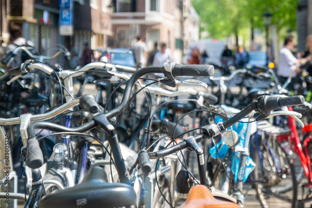 typical dutch transportation scenery. lots of parked bicycles in a row on a parking lot for bikes in a city centre in the Netherlands, Europe on a sunny day. typical dutch transportation scenery. lots of parked bicycles in a row on a parking lot for bikes in a city centre in the Netherlands, Europe on a sunny day.