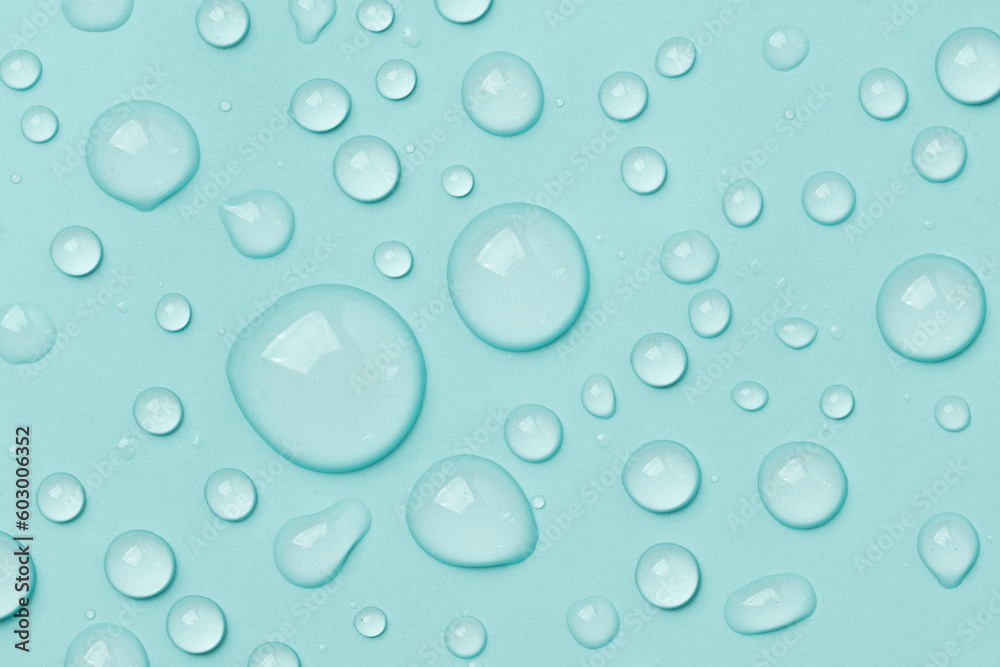 Water drops on blue background top view. Cosmetic moisturizing liquid drops of toner or hyaluronic serum.