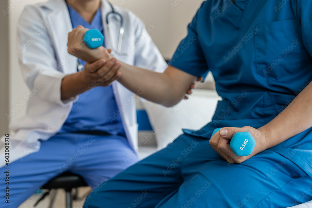 Using dumbbell, Physiotherapy specialists help patients in physiotherapy. about Muscle Weakness and Fatigue Using dumbbell, Physiotherapy specialists help patients in physiotherapy. about Muscle Weakness and Fatigue