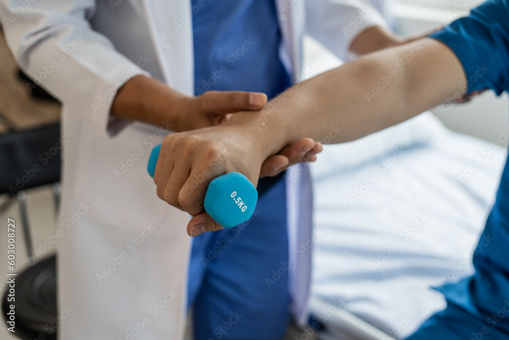 Using dumbbell, Physiotherapy specialists help patients in physiotherapy. about Muscle Weakness and Fatigue Using dumbbell, Physiotherapy specialists help patients in physiotherapy. about Muscle Weakness and Fatigue