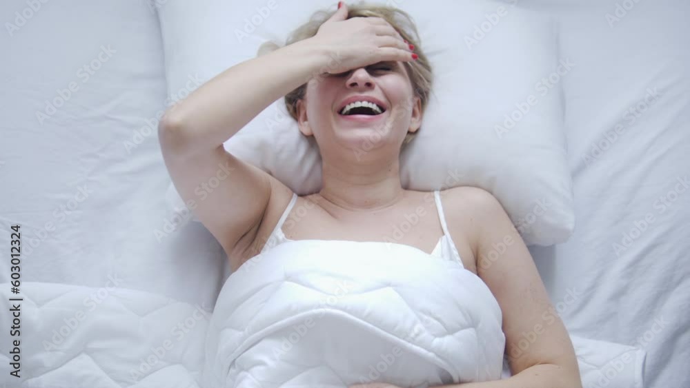 Female patient of clinic for the mentally ill lying in bed with white